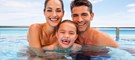 Happy family smiling in the infinity pool at Generations Riviera Maya oceanfront luxury Jacuzzi suite