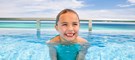 Adorable girl swimming in the infinity pool at Generations Riviera Maya Mexico